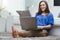 Young woman on soft carpet using laptop