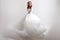 Young woman spinning in a curvy wedding dress. woman bride in lavish wedding dress. Light background.