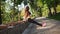 Young woman in sport bra and leggins doing reverse push ups in the park listening to the music. Slowmotion shot