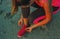 Young woman in a sporting suit tying shoelaces on beach sand