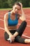 Young Woman in Sports Bra Resting on Track