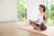 Young woman in sportswear doing meditation practice and yoga indoor, healthy lifestyle, Mental health concept