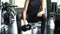 Young woman in sportswear doing seated dumbbell concentration curl bicep exercise at the gym.