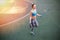 Young woman in sportswear exercising with skipping rope on stadium