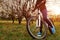 Young woman in sportswear riding bicycle in spring forest. Helathy lifestyle concept. Close-up of bike wheel