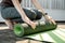 Young woman in sportswear is rolling up the mat and prepare laptop for yoga exercise class online