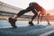 Young woman in sportswear in starting position on running track stadium