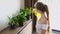 Young Woman Spray Water on Flowers from Watering Can, Taking Care, Growing Plant