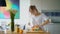 Young woman squeezing fresh orange juice with citrus squeezer