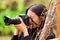 Young woman stalking and taking pictures with her camera, at outside