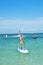 Young woman stand up on board and man posing at new flyboard at Caribbean tropical beach. Standup paddleboarding. Positive human e