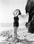 Young woman standing on the beach and smiling