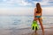 Young woman standing on the cliff and holding a mask and snorkel. Snorkeling or scuba diving tropical vacation