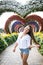 Young woman standing in colorful heart shaped flowers alley in Dubai Miracle Garden