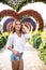 Young woman standing in colorful heart shaped flowers alley in Dubai Miracle Garden