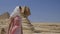 Young woman standing in front of the Great Sphinx of Giza.