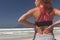 Young woman standing with hand behind back at beach