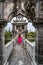 Young woman standing hands up on bridge to Gili Bale in Ujung Water Palace Ujung Park or Sukasada Park on Bali, Indonesia