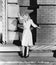 Young woman standing on the ledge of a building and looking feared