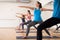 Young woman standing in lunging asana Virabhadrasana in yoga studio