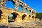 Young woman standing near Aqueduct Pont du Gard in southern France