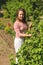 Young woman standing near a bush currants