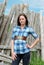 Young woman standing near old wood post fence