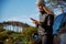 Young Woman Standing Next To Broken Down Car Trying To Get Signal On Mobile Phone