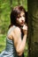 Young woman standing next to tree