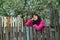 Young woman standing by old fence and dreamy looking