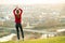 Young woman standing outdoors enjoying city view. Relaxing, freedom and wellness concept