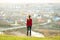 Young woman standing outdoors enjoying city view. Relaxing, freedom and wellness concept