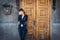 Young woman standing over old wooden door and holding head