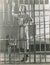 Young woman standing in prison cell