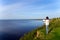 Young woman standing on the shore of the lake with blank sheet o