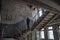 Young woman standing at stairs in the abandoned building at the ghost town Chernobyl