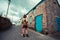 Young woman standing in street outside old house