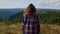 Young woman standing on top of mountain alone. Female hiker enjoying vacation