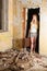 Young woman standing with vintage suitcase in old building