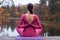 Young woman standing in yoga posture on wooden bridge in autumn