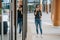 Young woman is standng and speaking with mobile phone with a happy smile and her reflection