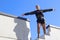 A young woman stands high up on a staircase with open arms