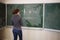 Young woman stands near blackboard with pictures
