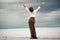 Young woman stands on sand in desert. Back view.