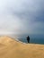 A young woman stands sandy dunes on seashore. Sandwich Harbour in Namibia.