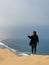 A young woman stands sandy dunes on seashore. Sandwich Harbour in Namibia.