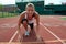 Young Woman at Starting Line on Running Track