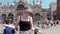 Young woman startled as a pigeon lands on her outstretched arm  St Mark\\\'s Square in Venice  Italy