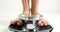 Young woman stepping on an old fashioned scale