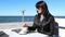 Young woman stirring  coffee with a teaspoon in an outdoor cafe